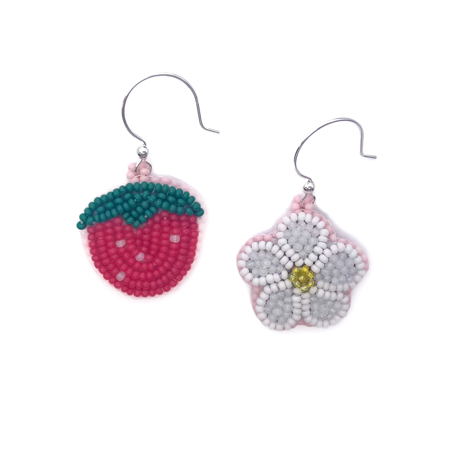 Two beaded earrings, one resembling a strawberry and the other a flower, on a white background.
