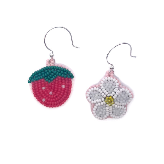 Two beaded earrings, one resembling a strawberry and the other a flower, on a white background.